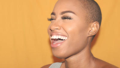 woman smiling mouth open yellow background